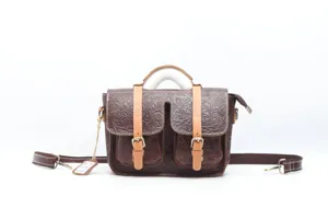 Vintage brown leather embossed messenger bag detail showing buckle and double front pockets.