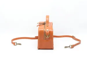 Side detail view of orange vegetable-tanned leather women crossbody Boston handbag.