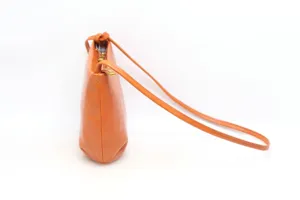 Minimalist orange leather shoulder bag detail, vintage style crossbody bag with thin strap.