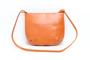 Detail shot of vintage minimalist leather shoulder bag strap and texture closeup view.