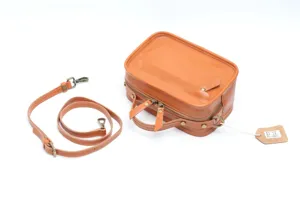 Leather boston handbag detail view, tan shoulder bag with detachable strap and hardware.
