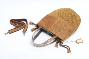 Close-up detail of woven leather bucket bag showing fine texture and detachable strap.