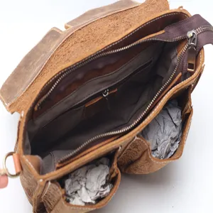 Vintage brown leather messenger bag with multiple pockets and shoulder strap for women.