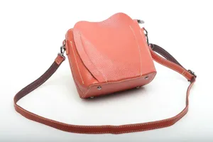 Elegant genuine leather crossbody bag for women, stylish orange shoulder bag with flap design.