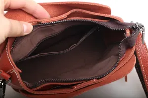 Detailed interior view of a genuine leather crossbody bag with multiple zipper compartments.