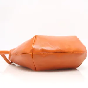 Vintage genuine leather shoulder crossbody bag in vibrant orange, low angle view display.