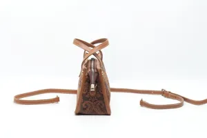 Vue détaillée du sac à main vintage en cuir marron avec motif gaufré et profil latéral.
