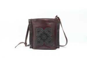 Close-up detail of vintage genuine leather shoulder bag, unique embossed pattern, brown design.