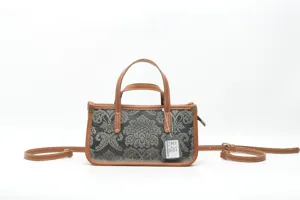 Vue détaillée du sac à main en cuir vintage avec motif damas, bordures et poignées marron.