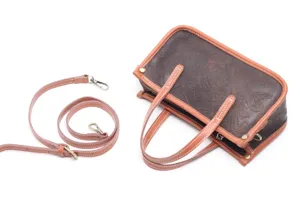 Vue détaillée du sac à main en cuir gaufré vintage avec poignées et bandoulière.