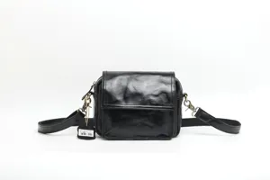 Close-up detail of genuine leather vintage crossbody bag texture hardware and strap craftsmanship.