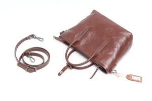 Detail view of brown genuine leather women handbag, square tote with detachable shoulder strap.