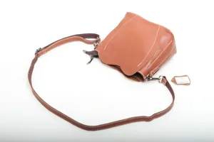 Leather crossbody bag for women, stylish brown shoulder bag with strap and metal zipper detail.