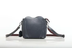 Dark blue cowhide leather cross-body shoulder bag with unique heart shape design and straps.
