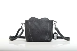 Close-up detail of the black leather crossbody bag featuring unique heart flap and white stitching.