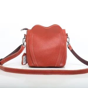 Genuine leather crossbody bag for women, orange stylish shoulder bag with heart flap design.