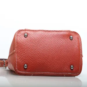 Genuine leather cowhide shoulder bag bottom view showing pebble grain texture and metal feet.