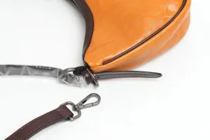 Vista dettagliata della elegante borsa a tracolla in pelle sotto l'ascella dal design unico.
