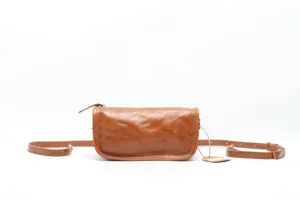 Detail view of genuine leather brown crossbody bag, showing fine texture and hardware.