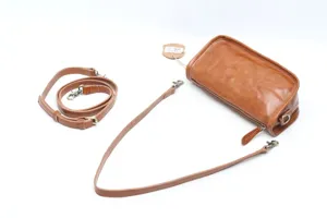 Detail view of genuine leather cylindrical bag, showing texture, zipper, and adjustable straps.