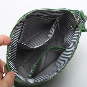 Green genuine leather crossbody bag with striped interior lining and multiple zip compartments.