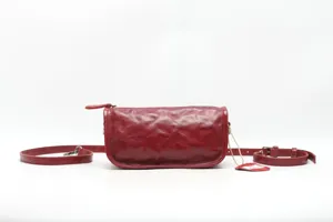 Close-up detail of the red crinkled leather shoulder bag showing texture and craftsmanship.