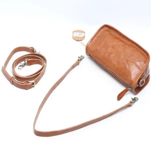 Retro brown leather cylinder shoulder bag for women, stylish commuter crossbody handbag with strap.