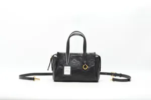 Black genuine leather handbag detail showing metal ring accent, dual handles and strap.