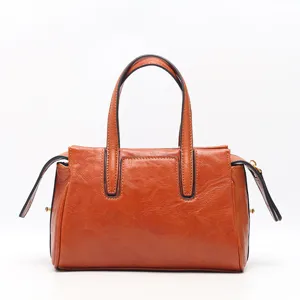 Classic retro brown leather handbag for women, versatile top-handle crossbody fashion bag.