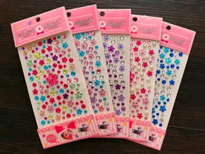 Close-up of packaged 3D crystal gemstone and flower stickers in various bright colors
