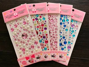 Macro view of multiple colorful 3D crystal rhinestone sticker sheets for kids decoration.