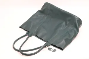 Detailed view of dark green genuine leather tote bag, minimalist cowhide shoulder handbag.