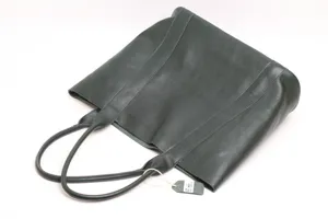Detailed view of dark green leather tote bag showing premium texture and sturdy shoulder strap.
