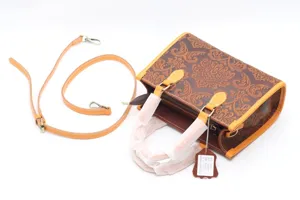 Gros plan détaillé du sac à main vintage en cuir gaupré marron avec poignée et sangle.