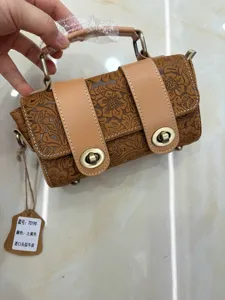 Detailed view of embossed genuine leather retro women handbag shoulder cross body bag.