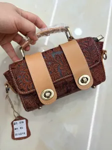 Vintage embossed genuine cowhide leather shoulder handbag with retro twist-lock closure.