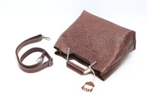 Brown leather embossed shoulder bag detail view showing retro style and hardware texture.