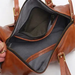 Vintage brown leather barrel bag open view showing interior zipper pocket and spacious lining.