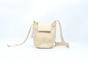 Detailed view of the beige genuine cowhide bucket bag, showing premium leather texture.