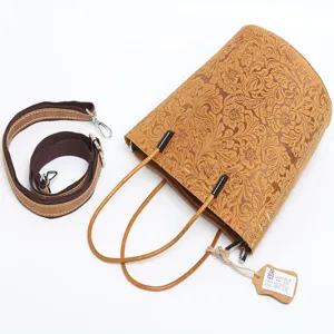 Genuine leather bucket bag with retro floral tooling, top handle and adjustable strap.