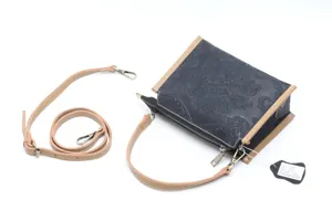 Close-up detail view of vintage embossed genuine leather shoulder bag with stylish tan strap.