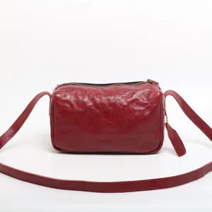 Classic red leather vintage cylinder shoulder bag for women, soft crossbody pillow purse.