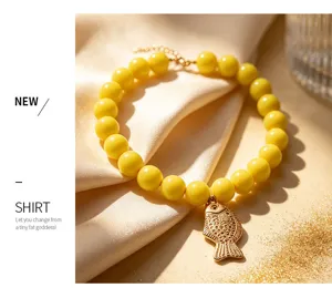 Détail du collier avec pendentif poisson doré et perles jaunes, design élégant pour tous les jours.