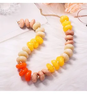 Détail de collier de perles en résine colorée, style dopamine avec grosses perles vives.