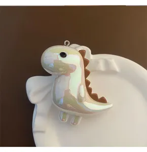 Gros plan détaillé du porte-clés pendentif dinosaure en acrylique irisé avec finition brillante.