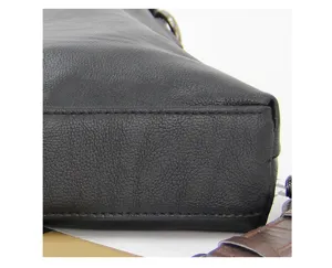 Detail view of black leather business men briefcase showing fine texture and neat stitching work.