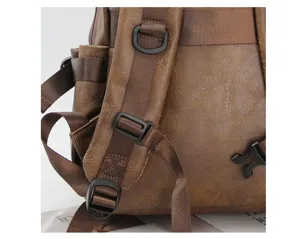 Detailed view of brown vintage backpack strap, adjustable buckles and durable fabric.