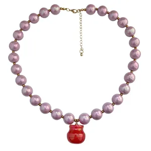 Collana di perle acriliche viola bohémien con ciondolo rosso e distanziatori dorati