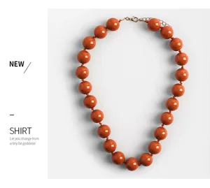 Chunky orange acrylic bead statement necklace for women, stylish boho fashion jewelry detail.