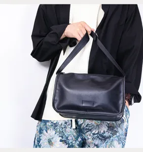 Close-up detail view of the black leather shoulder bag, minimalist crossbody messenger bag style.